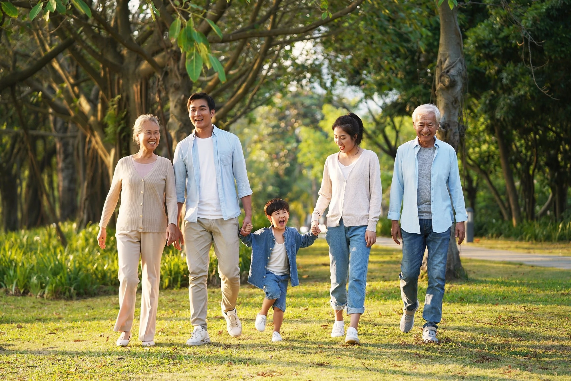 An Asian Family Strolls Together In A Park